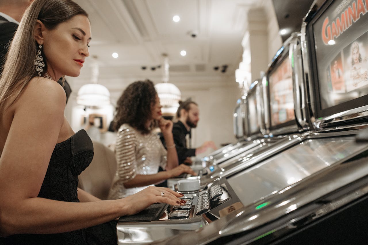 Stylish women engage in casino gaming at slot machines, showcasing elegance and excitement.