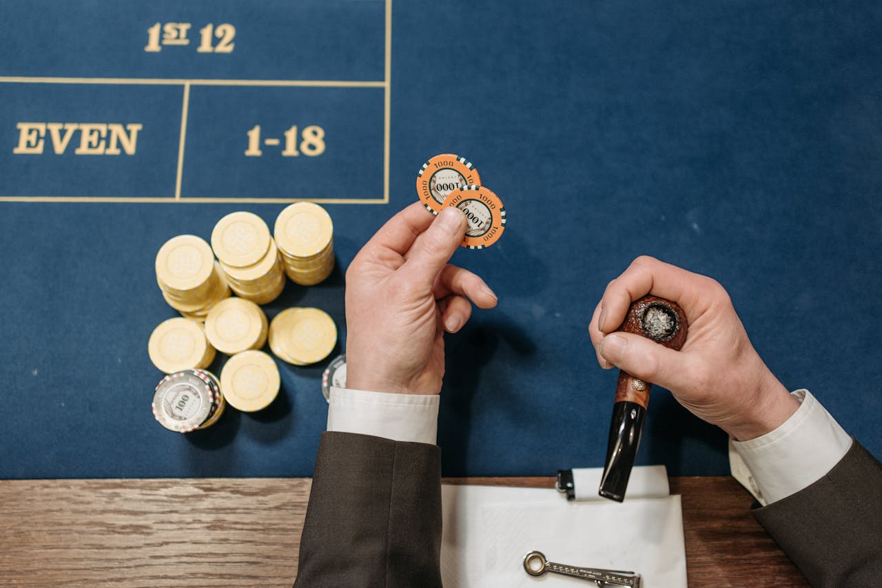 about-02 Overhead view of a casino table with poker chips and a tobacco pipe, depicting a gambling scene.